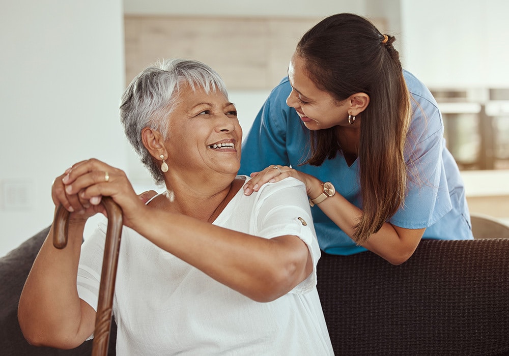 A senior smiling at a nurse.